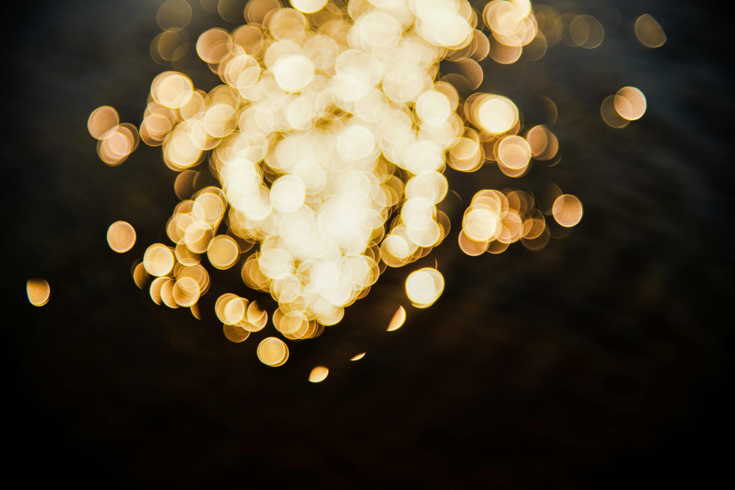 Abstract photo capturing bokeh light effects in a circular pattern against a dark background.